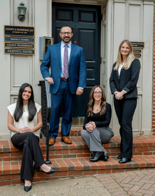 Ciconte Wasserman's team of four legal professionals standing smiling outside their downtown Wilmington office.