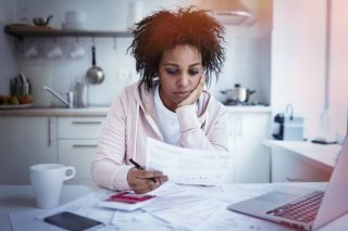 Young woman reviewing insurance documents at a table after a car accident