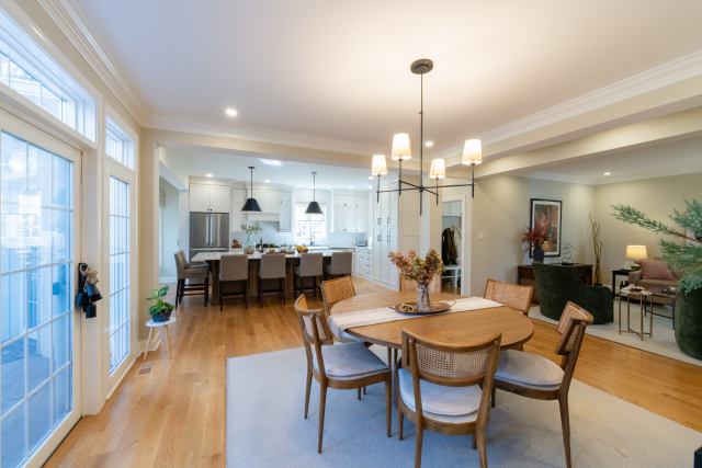 Bright Dining Area and Peninsula
The redesigned peninsula integrates storage and counter space, with the granite finish extending into the dining area for a unified design. Consistent flooring and recessed lighting connect the spaces seamlessly.