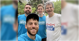 Jason Hoover and four volunteers in blue campaign shirts take a selfie outdoors before a lit drop in District 4, Wilmington.