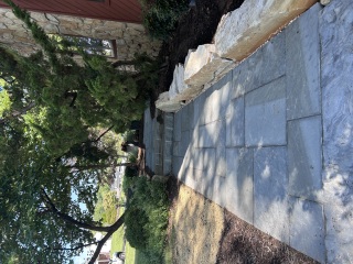 Completed bluestone walkway in Media PA with broad natural stone steps and a low boulder wall beside a stone house