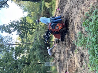 Crew working beside a Ditch Witch SK800 auger attachment during tree planting preparation