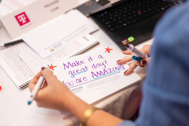 Participant decorating a United Way encouragement card with colorful stars and the message Make it a great day! You are AMAZING.