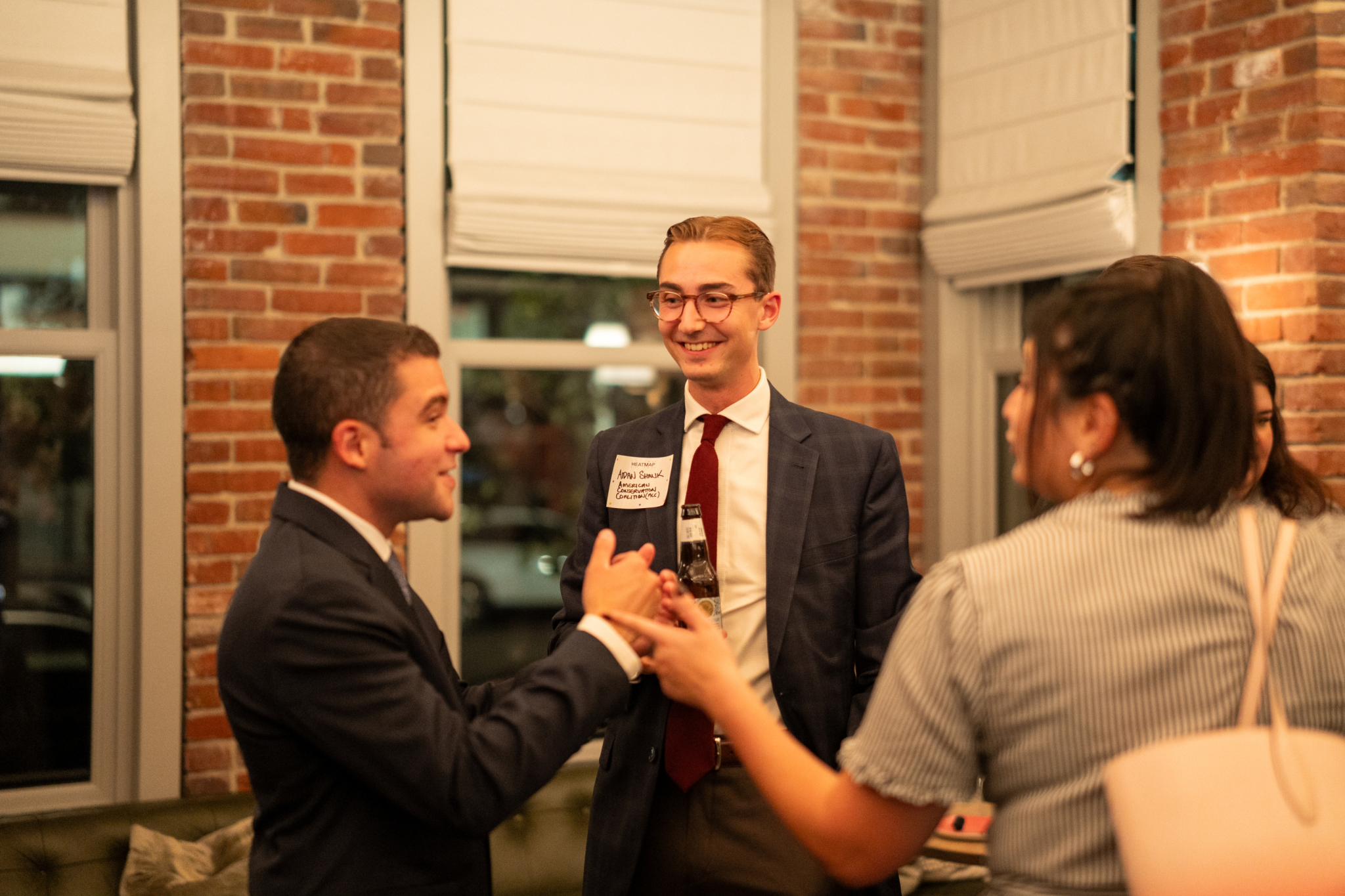 Networking attendees photographed under strong warm interior lighting