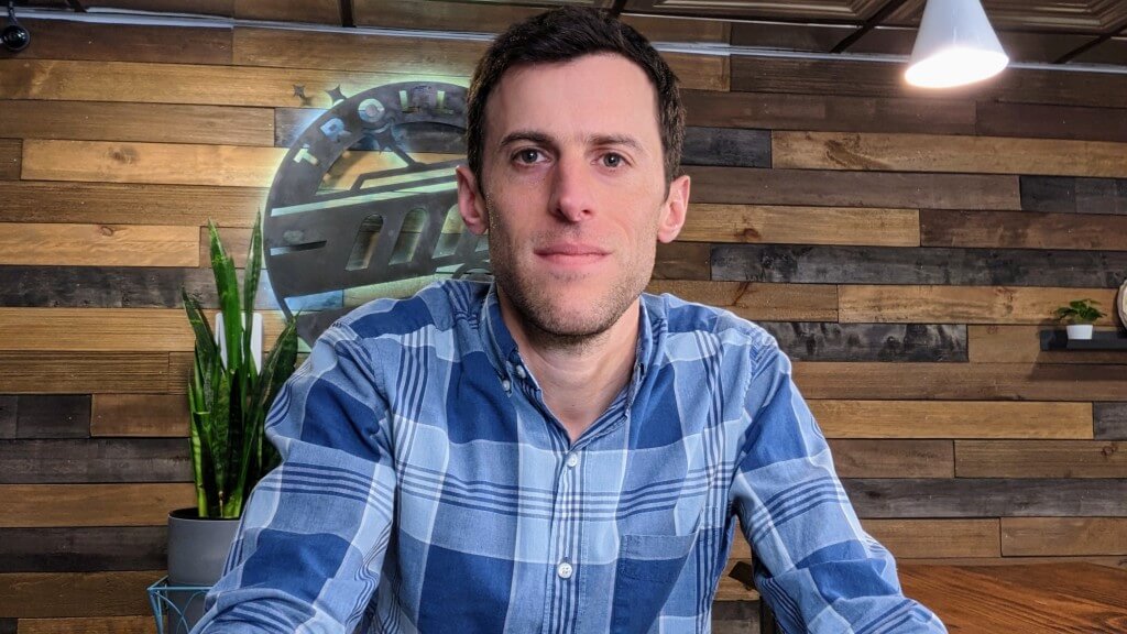 Jason Hoover of Trolley Web, a website design company serving Philadelphia, in the office with wood paneling in the background
